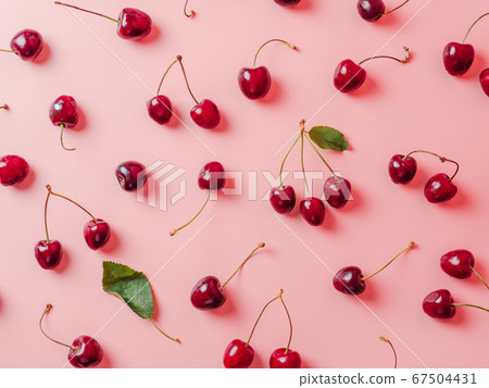 Fresh cherries scattered on pink background 67504431