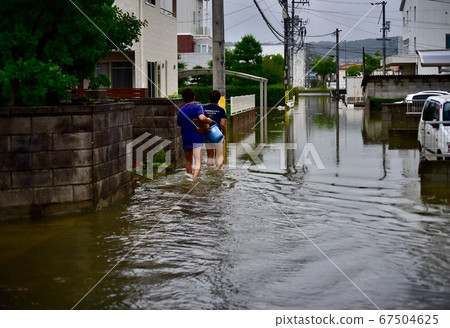 在日本西部大雨災難中，兩名男子從一間被水淹沒的房屋中疏散 67504625
