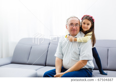 Funny lifestyle portrait of grandchild embracing grandfather Funny lifestyle portrait of grandchild embracing grandfather 67504887
