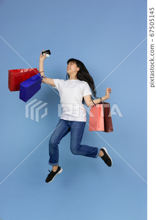 Portrait of young asian woman isolated on blue studio background Portrait of young asian woman isolated on blue studio background 67505145