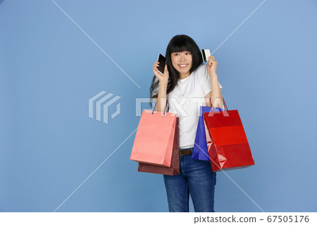 Portrait of young asian woman isolated on blue studio background Portrait of young asian woman isolated on blue studio background 67505176