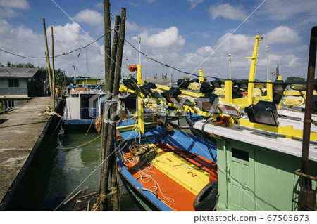 Traditional fishing village with lovely sky and fishing boat moored near the shore Traditional fishing village with lovely sky and fishing boat moored near the shore 67505673