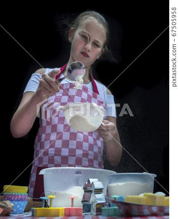 Selective focus. Girl sifting flour adding baking ingredients. Selective focus. Girl sifting flour adding baking ingredients. 67505958