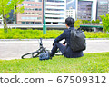 A man who takes a break on the way to work by bicycle 67509312
