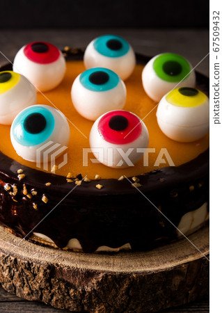 Halloween cake with candy eyes decoration on wooden table 67509432