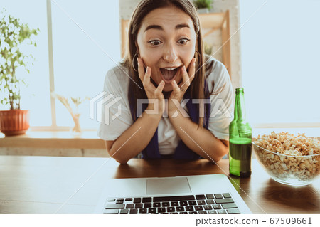 Excited football fan watching sport match at home, remote support of favourite team during coronavirus pandemic outbreak 67509661