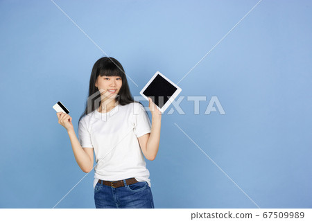 Portrait of young asian woman isolated on blue studio background Portrait of young asian woman isolated on blue studio background 67509989