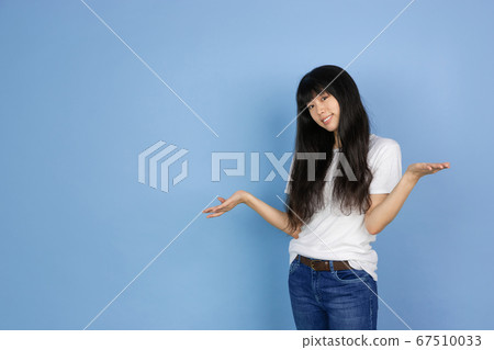 Portrait of young asian woman isolated on blue studio background 67510033