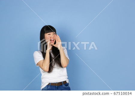 Portrait of young asian woman isolated on blue studio background 67510034