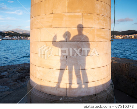Heterosexual couple makes funy shadows on wall Heterosexual couple makes funy shadows on wall 67510378
