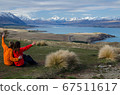 Two people sitting and looking at Lake tekapo from Mount John observatory, South Island, New Zealand 67511617