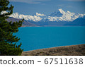 Distant view of Mount Cook across Lake Pukaki with tree on the left, South Island, New Zealand 67511638