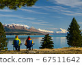 Two people sitting on camping chairs looking at distant Mount Cook across Lake Pukaki, South Island, New Zealand 67511642