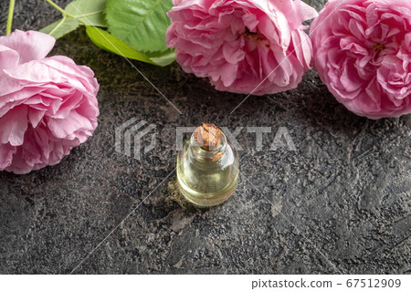 A bottle of rose essential oil with rose de mai A bottle of rose essential oil with rose de mai 67512909