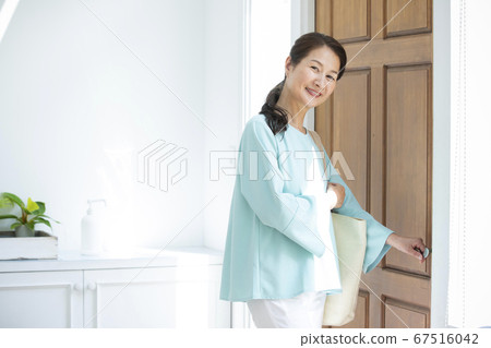 Woman opening the front door 67516042