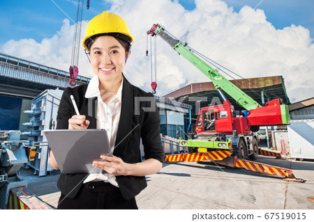 Young woman engineer holding digital tablet wtih 67519015