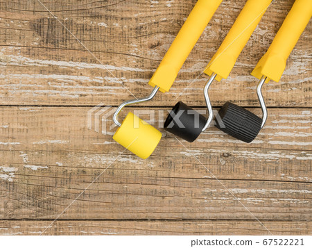 Rollers for Wallpaper on a wooden background. 67522221