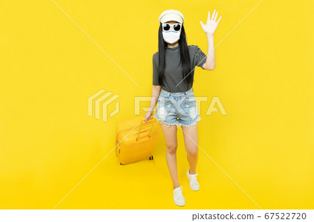Young asian woman wearing a mask to protect against Corona virus. covid19 disease,Drag a luggage, cheerful fun enjoy to travel at the airport. New normal ,Vacation,summer,holidays and travel concept Young asian woman wearing a mask to protect against Corona virus. covid19 disease,Drag a luggage, cheerful fun enjoy to travel at the airport. New normal ,Vacation,summer,holidays and travel concept 67522720
