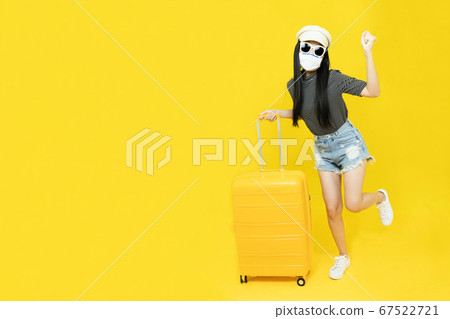 Young asian woman wearing a mask to protect against Corona virus. covid19 disease,Drag a luggage, cheerful fun enjoy to travel at the airport. New normal ,Vacation,summer,holidays and travel concept Young asian woman wearing a mask to protect against Corona virus. covid19 disease,Drag a luggage, cheerful fun enjoy to travel at the airport. New normal ,Vacation,summer,holidays and travel concept 67522721