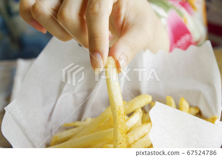 Female hand picking french fries 67524786