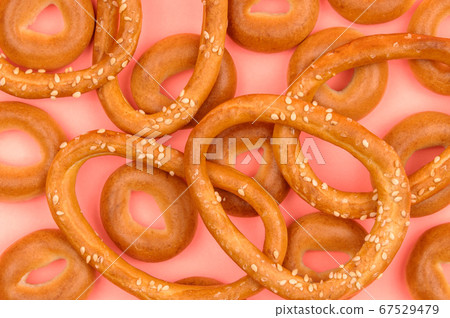 Large and small bagels on a pink background. Large and small bagels on a pink background. 67529479