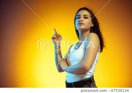 Portrait of young caucasian woman isolated on gradient yellow studio background Portrait of young caucasian woman isolated on gradient yellow studio background 67530134