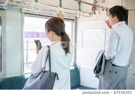 Woman looking at mobile on the train 67530205