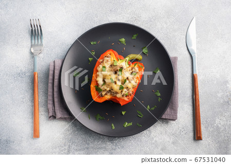 Stuffed sweet peppers with rice mushrooms and cheese with herbs. Baked halves of red pepper with filling. Grey concrete background. Copy space, 67531040