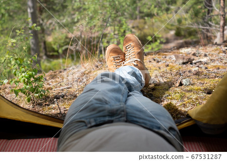 Male boots looking out of the tent during rest after hiking. Male boots looking out of the tent during rest after hiking. 67531287
