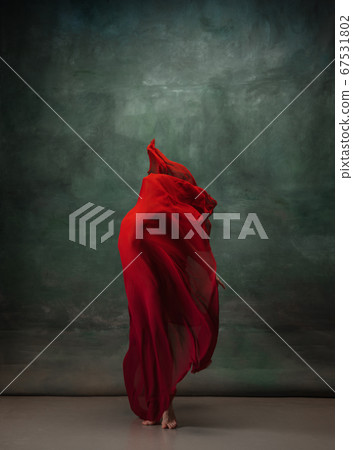 Young graceful tender ballerina on dark green studio background 67531802