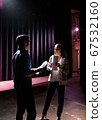 Two young actors rehearsing a scene on stage, dark lighting 67532160