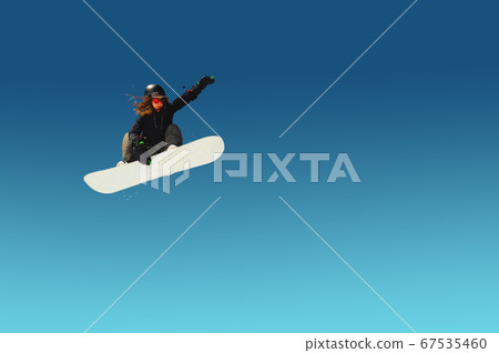 Girl snowboarder in flight after jumping amid blue sky gradient blank designer winter snowboarding sport Girl snowboarder in flight after jumping amid blue sky gradient blank designer winter snowboarding sport 67535460
