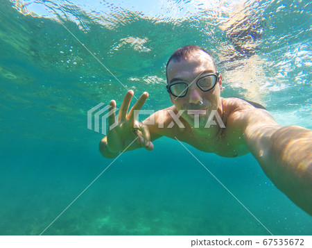 man swims underwater 67535672