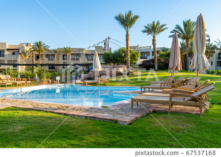 Luxury resort with swimming pool, sun loungers and beach umbrellas. Oriental tropical hotel in Egypt 67537168