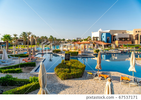 Luxury resort with swimming pool, sun loungers and beach umbrellas. Oriental tropical hotel in Egypt 67537171
