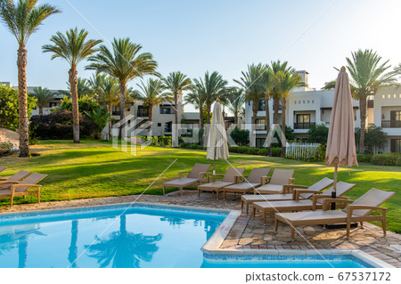 Luxury resort with swimming pool, sun loungers and beach umbrellas. Oriental tropical hotel in Egypt 67537172