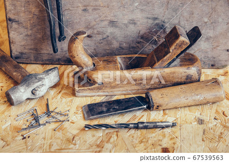 Old construction tools on a wooden workbench flat lay background. Carpenter table. Woodwork Old construction tools on a wooden workbench flat lay background. Carpenter table. Woodwork 67539563