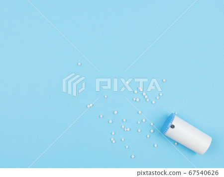 Homeopathic granules against a blue background. Homeopathic granules against a blue background. 67540626