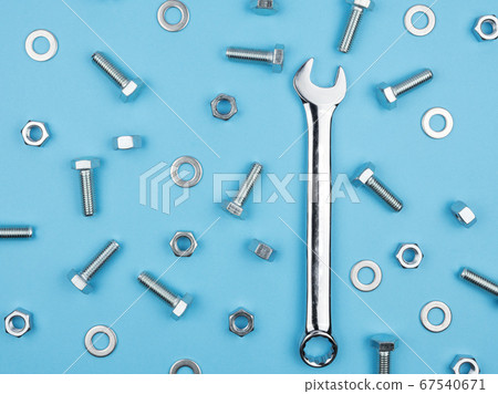 Wrench, nuts and bolts on a blue background. 67540671