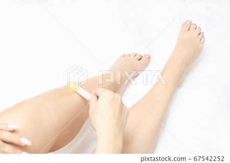 Waxing woman leg. Sugar hair removal. laser service epilation. Salon wax beautician procedure Waxing woman leg. Sugar hair removal. laser service epilation. Salon wax beautician procedure 67542252