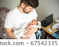 Father holds naked newborn son in his hands in a white diaper 67542335