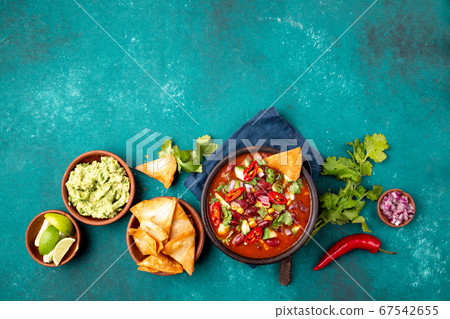 Mexican food concept background with chile black bean soup, guacamole and nachos totopos. Top view Mexican food concept background with chile black bean soup, guacamole and nachos totopos. Top view 67542655