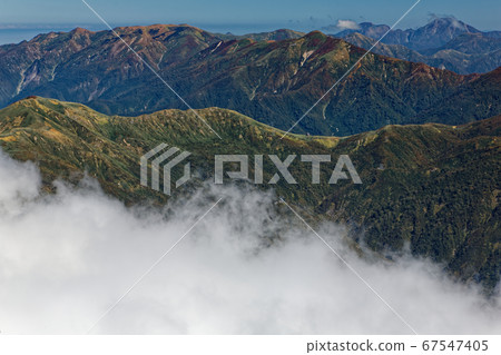 Mt. Mogura and Mt. Naeba with the autumn leaves seen from the Tanigawa mountain range and Mt. Ichinokura 67547405