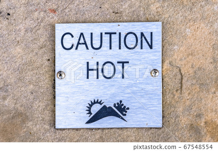 Caution Hot sign against a stone surface Caution Hot sign against a stone surface 67548554