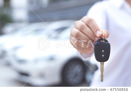 Man is holding car keys with car Man is holding car keys with car 67550958