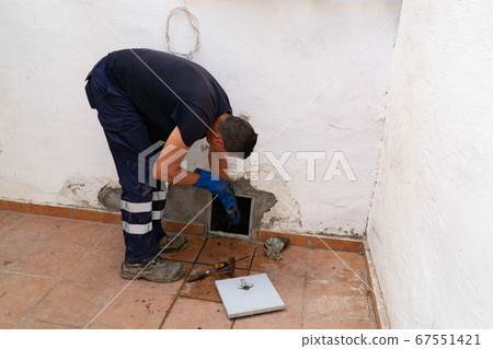 Worker cleans the drains hatch and removes dirt and debris from the sewer. Plumber cleans the sewer Worker cleans the drains hatch and removes dirt and debris from the sewer. Plumber cleans the sewer 67551421