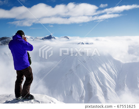 Skier at top of mount and snowy mountains in fog Skier at top of mount and snowy mountains in fog 67551625