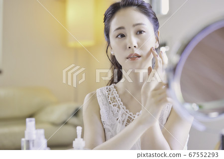 一名年輕女子在客廳裡照顧她的皮膚[擔心] 67552293
