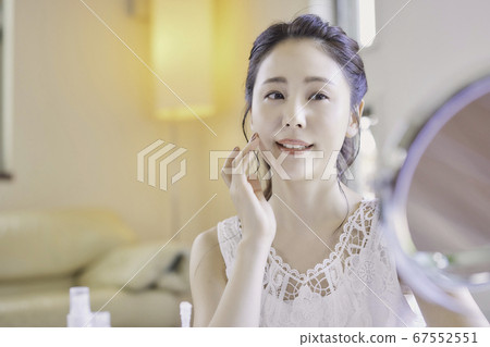 Young woman taking care of the skin in the living room Young woman taking care of the skin in the living room 67552551