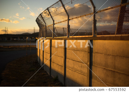 Exterior wall (iron fence) illuminated by the setting sun Exterior wall (iron fence) illuminated by the setting sun 67553592
